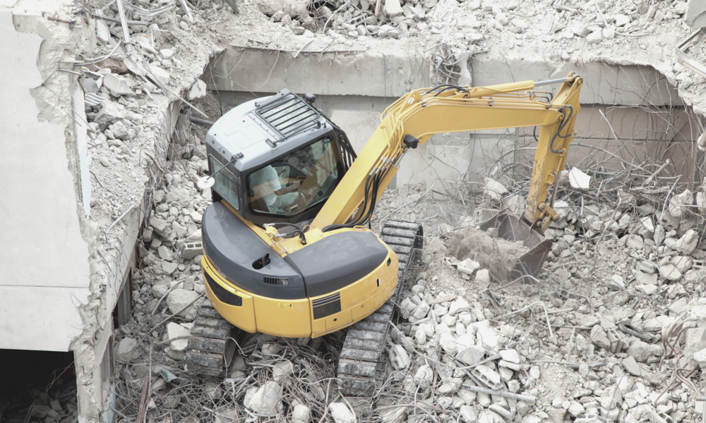 Abbruchzange sortiert Bauschutt auf der Baustelle