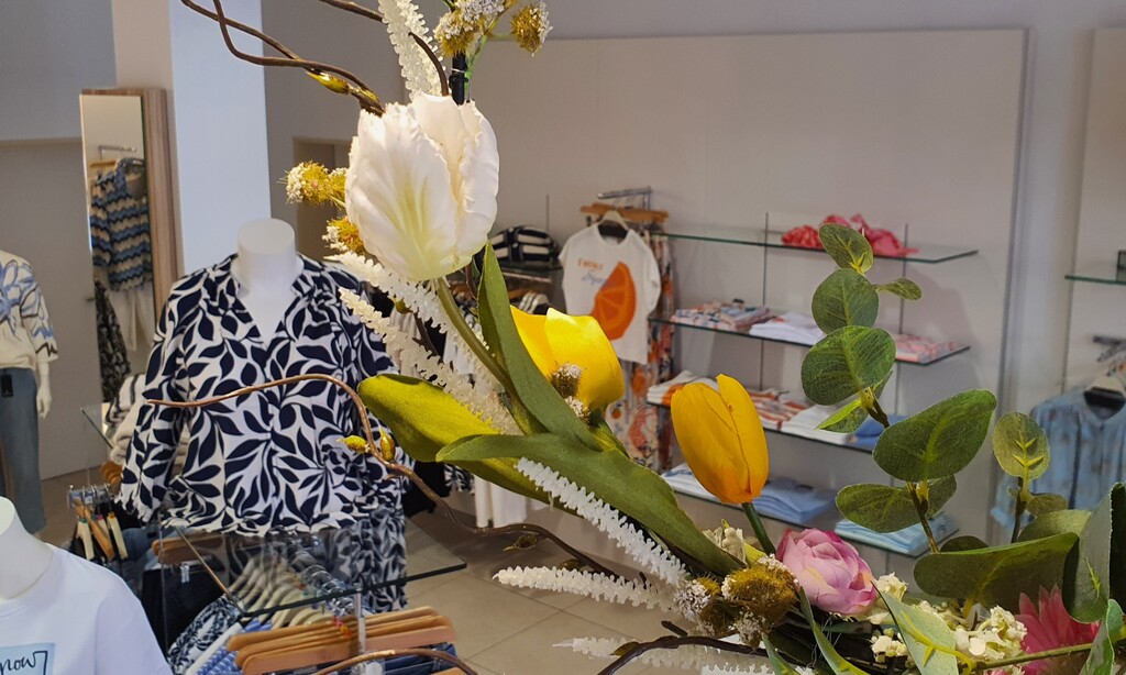 Bekleidungsgeschäft im Fokus von einem Blumenstrauß