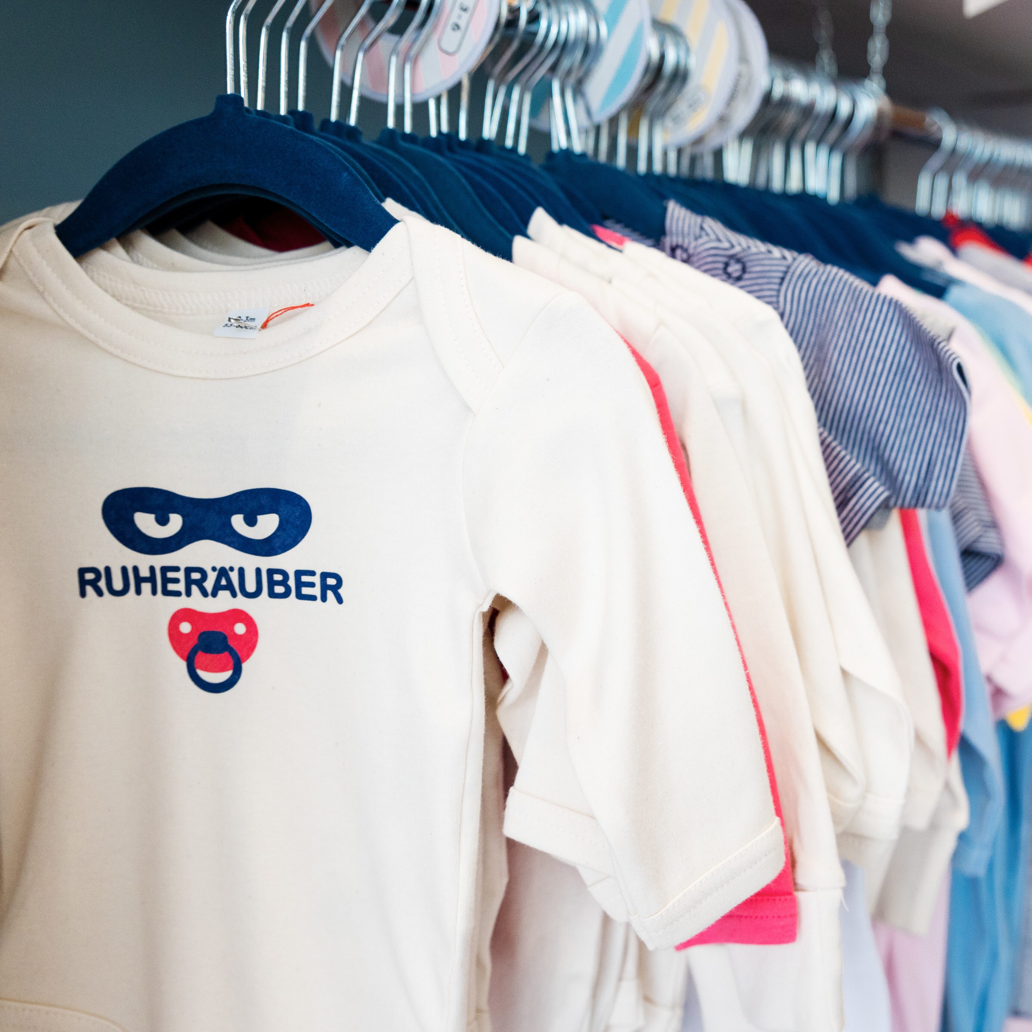 Baby-Geschenke Hamburg: eine Kleiderstange mit Baby-Kleidung