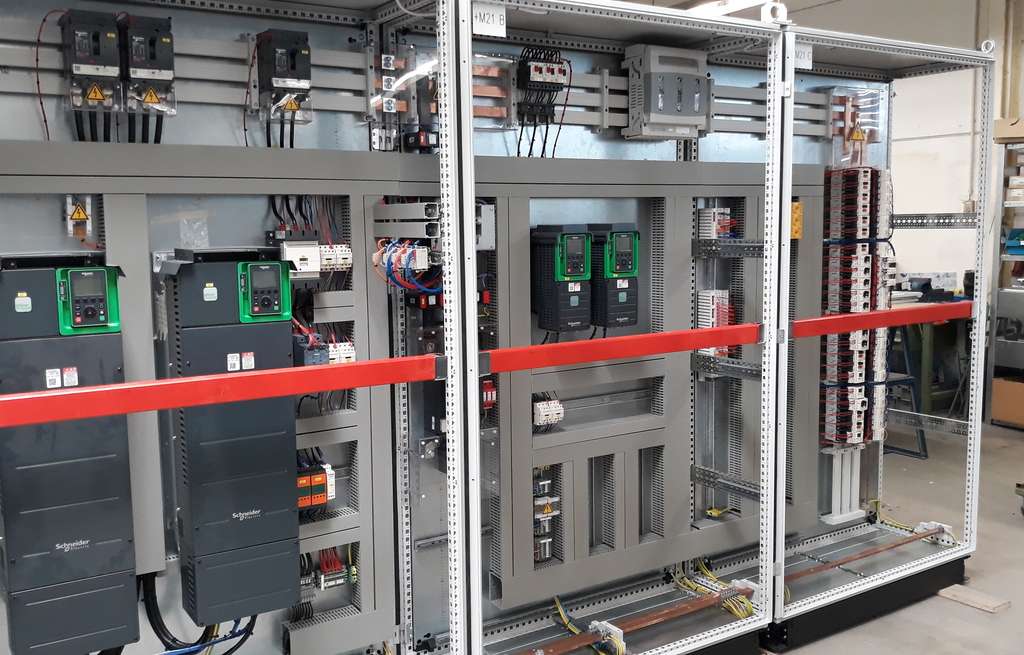 Nahaufnahme einer rotierenden Maschine mit orangefarbenen Befestigungen und Metallteilen in einer technischen Umgebung