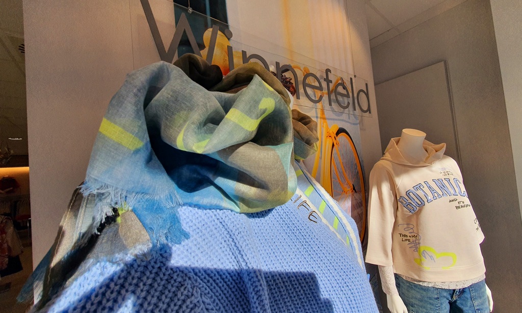 Schaufenster in dem zwei Schaufensterpuppen stehen, die Mode präsentieren