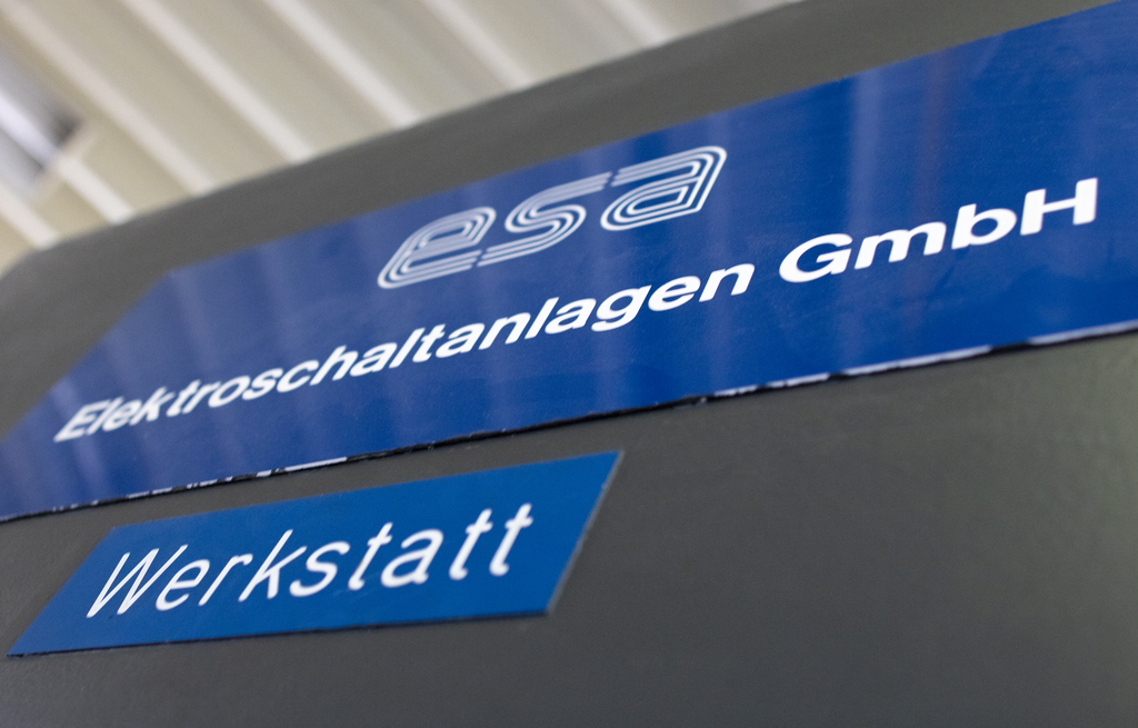 Nahaufnahme einer rotierenden Maschine mit orangefarbenen Befestigungen und Metallteilen in einer technischen Umgebung