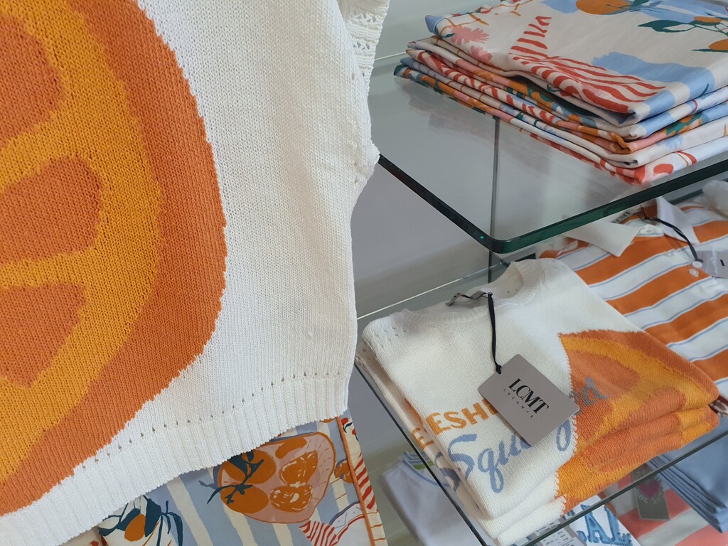 Bekleidungsablage mit orange hellblauer Kollektion