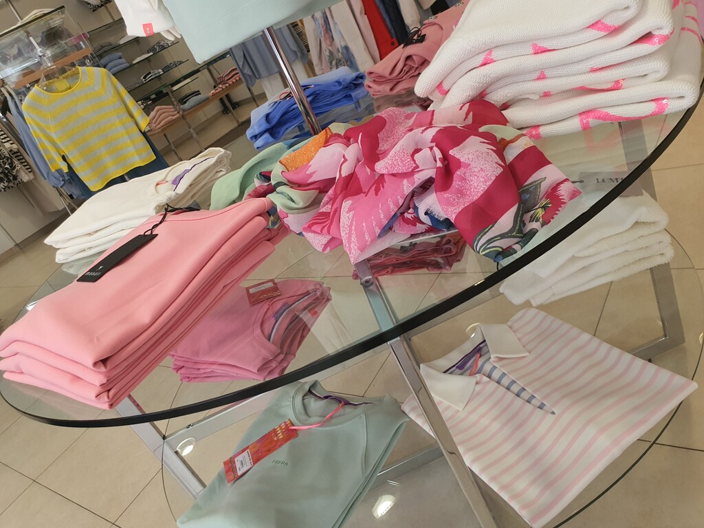 Glastisch auf dem rosane Bekleidung liegt