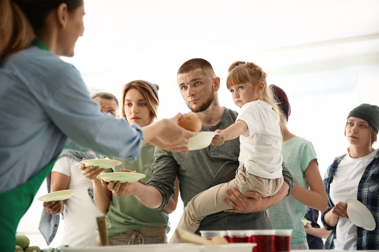 Man with his daughter at a food bank being served