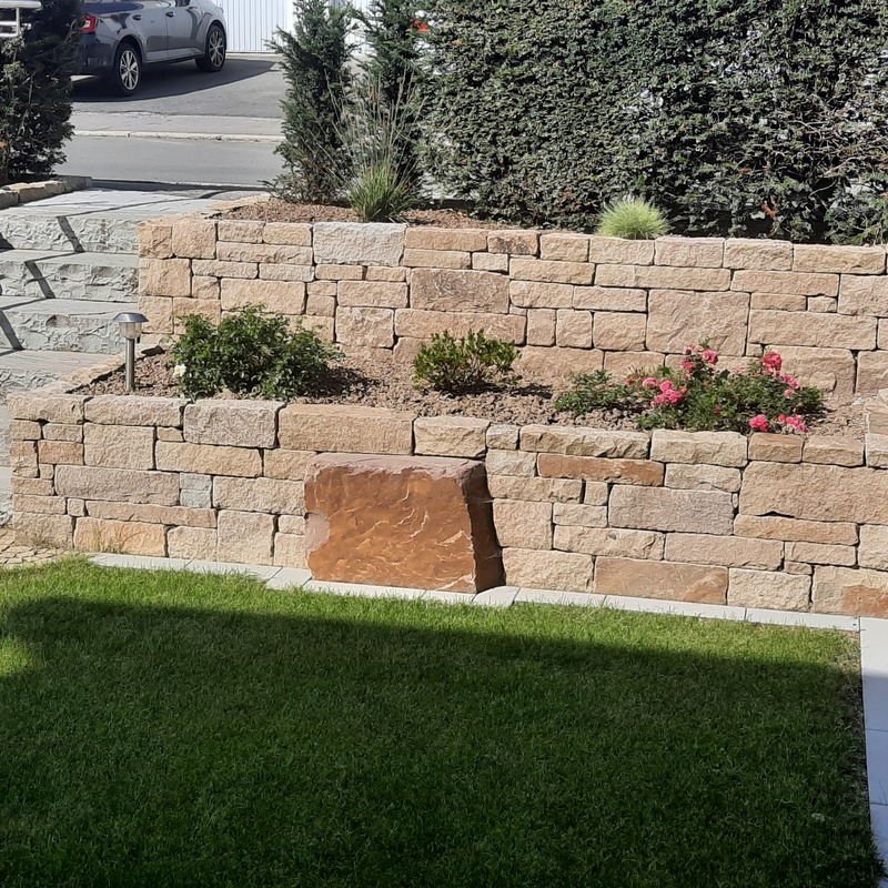Natursteinmauer im Garten mit Bepflanzung